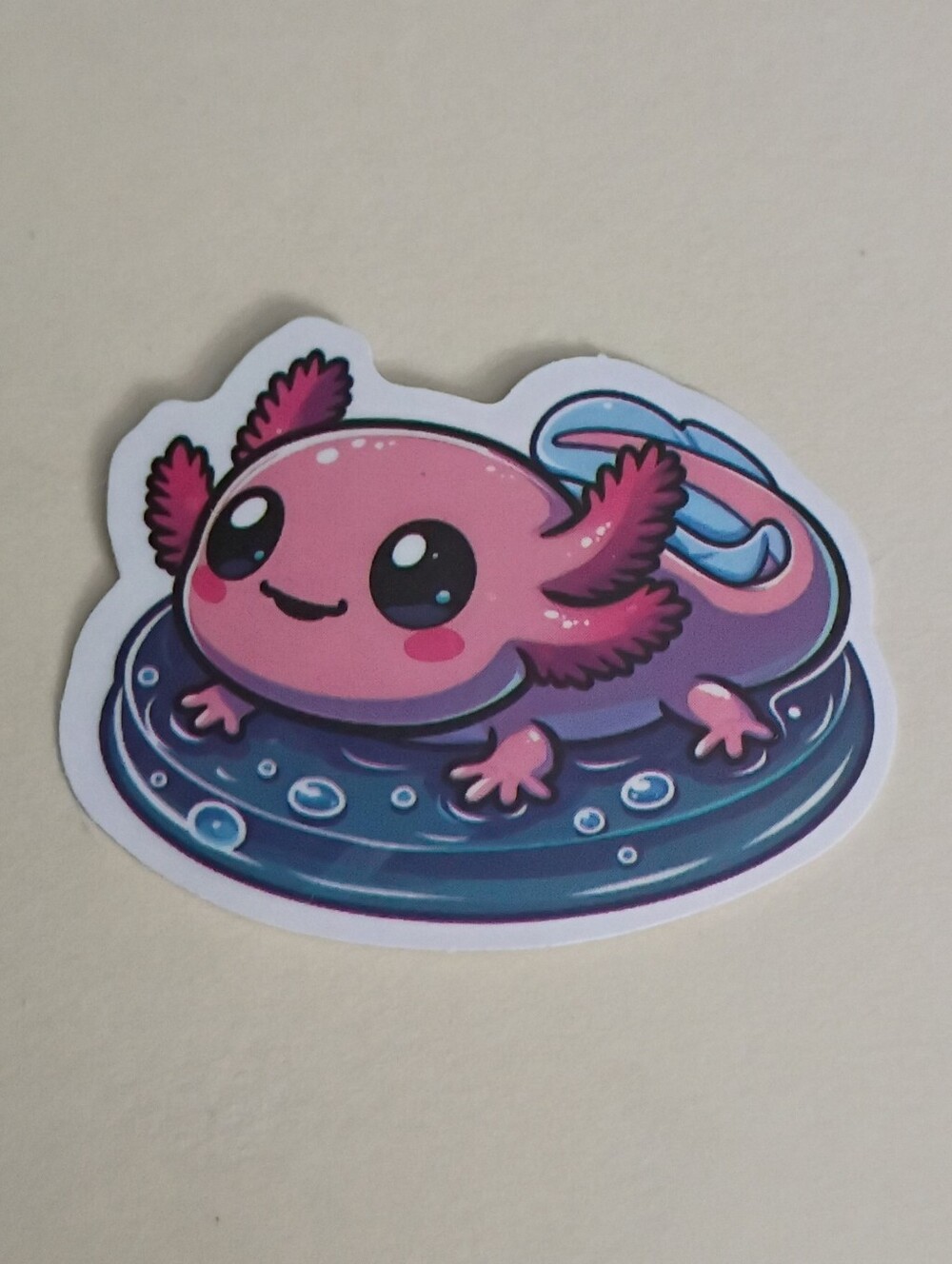 10/$10 Sticker - Pink Axolotl With Pink Cheeks & Blue Tail On Blue Pool Floaty